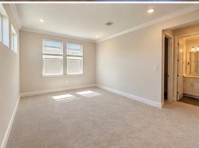 Bright carpeted secondary bedroom with en-suite bath access